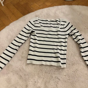 Randig ribbad tröja från H&M - Säljer en stilren vit och svart randig tröja från H&M. Tröjan är ribbad och har långa ärmar, perfekt för en avslappnad look. Passar bra till jeans eller kjol för en enkel men snygg outfit.