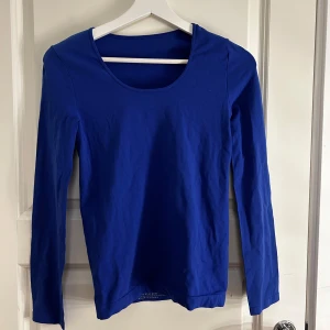 Blå långärmad tröja - Säljer en stilren blå långärmad tröja med rund halsringning. Perfekt för en avslappnad look eller som lager under en jacka. Passar bra till både jeans och kjol.