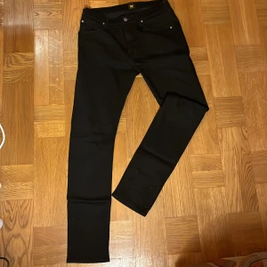 Svarta jeansbyxor från lee - Snygga svarta jeansbyxor från Luke i storlek W33 L34. De har en klassisk femficksdesign och är tillverkade i Vietnam. Perfekta för en stilren look.