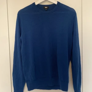 Blå tröja från Uniqlo - Säljer en stilren blå tröja från Uniqlo. Tröjan har en klassisk design med långa ärmar och rund hals. Perfekt för en avslappnad look.