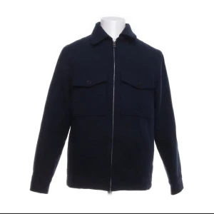 Mörkblå jacka från H&M - Snygg mörkblå jacka från H&M med dragkedja framtill och två bröstfickor med knappar. Jackan har en klassisk krage och långa ärmar, perfekt för en stilren look.                                      Nyskick, för stor för mig.                      Pris ej hugget i sten