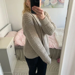 Beige stickad kofta från H&M - Mysig beige stickad kofta från H&M. Perfekt för kyliga dagar med sin grova stickning och långa ärmar. Enkel att matcha med olika outfits.