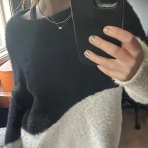 Svartvit fluffig tröja från Vila - Supermjuk och fluffig tröja från Vila i svart och vitt med coolt vågigt färgblock. Långärmad och lite oversized fit, perfekt för lager på lager. Materialet är stickat och känns riktigt cozy mot huden. Snygg till både jeans och kjol! Köpte för ungefär ett år sedan och användes i början, men tröttnade sedan. Inget slitage och ordinarie priset var ungefär 400 sek, nu säljs den för 230kr billigare. Finns ej att köpa i butik och kan kompromissa priset.