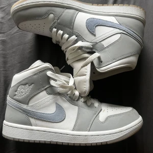 Nike Air Jordan 1 Mid grå/vit - GARDEROBSRENSNING! Använda fåtal gånger, saknar låda därav billigt pris! Små i storlek, jag har 39 och de passar mig!
