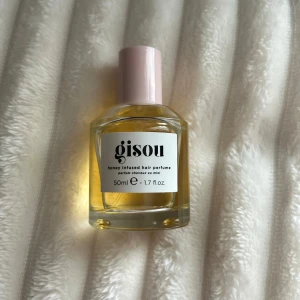 Gisou Honey Infused Hair Perfume 50ml - Gisou Honey Infused Hair Perfume i en stilren glasflaska med ljusrosa lock. Parfymen är gyllengul och kommer i 50 ml storlek. Doften är inspirerad av honung och passar perfekt för att fräscha upp håret med en söt och fräsch känsla. Så gott som ny använt ungefär 6 spray utav den.