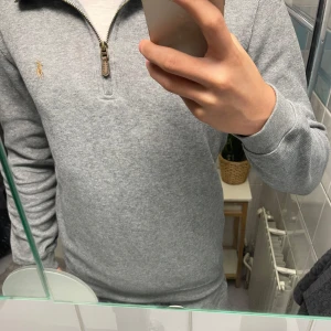 Grå half zip tröja från Polo Ralph Lauren - Snygg grå långärmad tröja från Polo Ralph Lauren med half zip och liten broderad logga på bröstet. Klassisk passform och mjukt bomullsmaterial, perfekt för lager-på-lager. Nästan aldrig använda så skick 10/10 