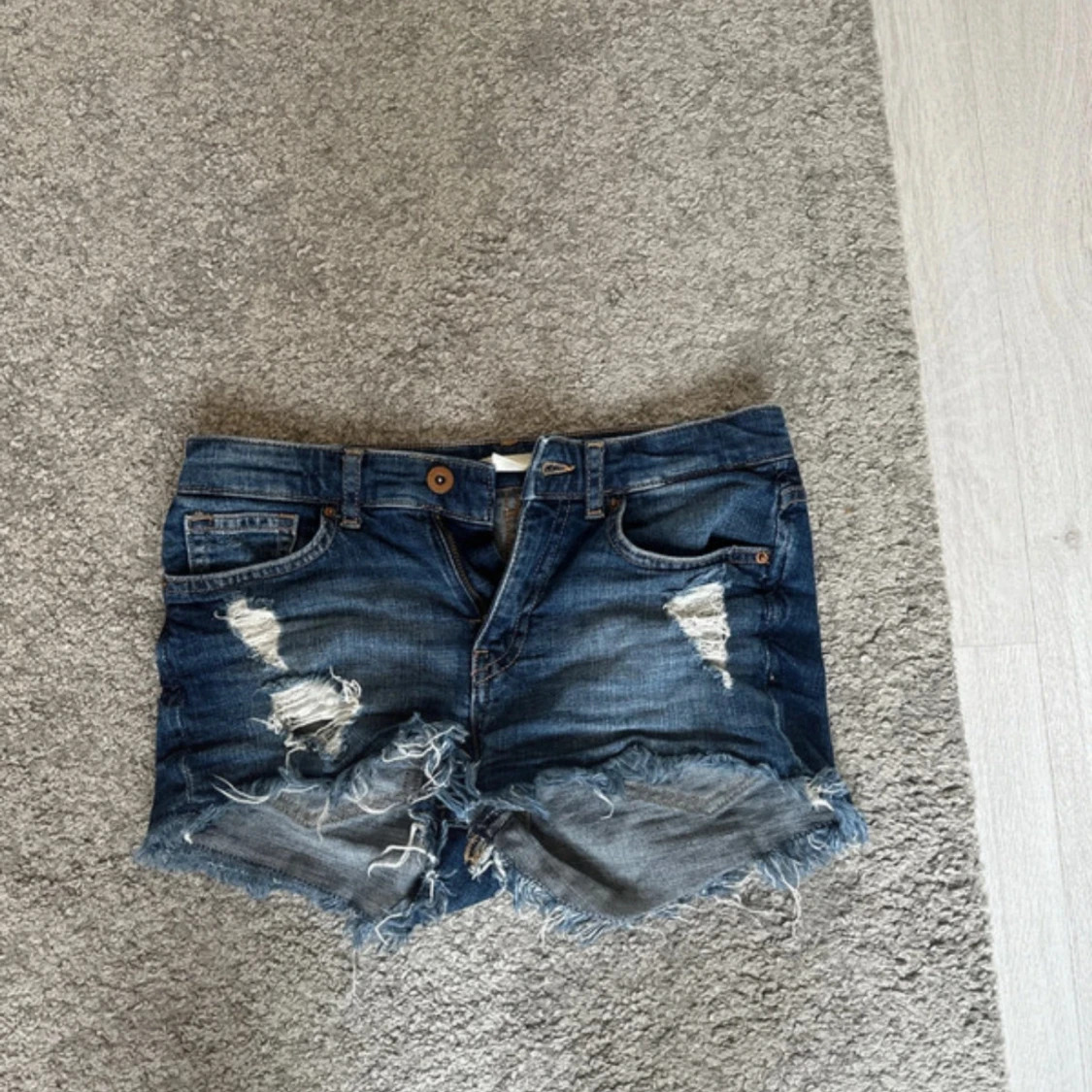 Blå slitna jeansshorts med fransar