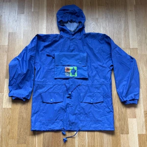 Vintage GAP Lila Regnjacka - Vintage GAP regnjacka som går att packa ner i en liten pouch i färgen lila.  Storlek: Barn L/XL eller vuxen XS/S, Armhåla till Armhåla: 57 cm, Längd: 71 cm, Axel till Armöppning: 57 cm.  Material: 70% PVC, 30% Nylon.