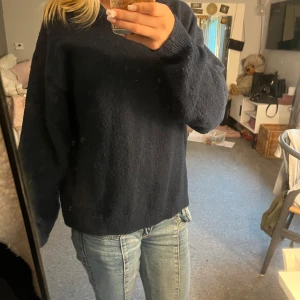 Mörkblå stickad tröja  - Mysig mörkblå stickad tröja från H&M i storlek XS. Tröjan har en enkel och klassisk design med rund halsringning och långa ärmar. Perfekt för lager-på-lager och chill dagar. Passformen är lite loose och materialet känns mjukt mot huden.
