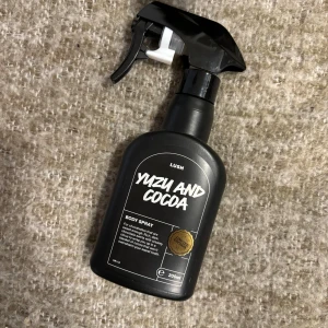 Lush Yuzu and Cocoa Body Spray 200ml - Lush Yuzu and Cocoa Body Spray i svart plastflaska med spraymunstycke. Doften kombinerar fräscha citrusnoter av yuzu med krämig chokladton från kakao. Endast testat 1-2 sprut!! Finns inte längre att köpa!! Passade tyvärr inte mig🥲, den är verkligen en otroligt doft annars!!💞💞