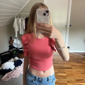 Korallfärgad blus från Zara - En korallfärgad blus med volangärmar från Zara. Storlek S men passar även mindre. Använd ett fåtal gånger. 