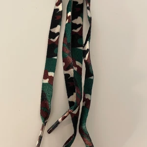 Nya skosnören grönt militärmönster  - Nya oanvända skosnören med grönt militärmönster. Frakt på 22kr tillkommer. Betalning sker via Swish.