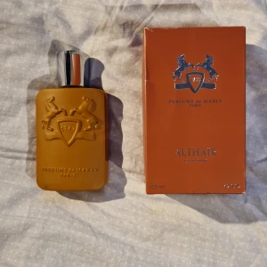 Parfums de Marly Althaïr EdP 125ml - Exklusiv parfym Althaïr från Parfums de Marly i en snygg matt brun flaska med silverdetaljer och reliefmönster. Doften är varm, amberaktig med tydliga inslag av trä och vanilj. Flaskan rymmer 125 ml och kommer i matchande brun kartong.