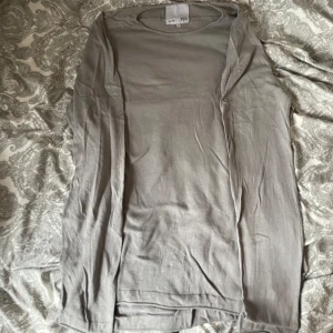 Ljusgrå långärmad tröja - En enkel och stilren ljusgrå tröja från Lager 157. Tröjan har en rak passform och är tillverkad i ett mjukt bomullsmaterial. Perfekt att slänga över en t-shirt för en clean look. Säljer en tröja i samma modell fast i Marinblå färg så köp gärna båda i ett bundle!