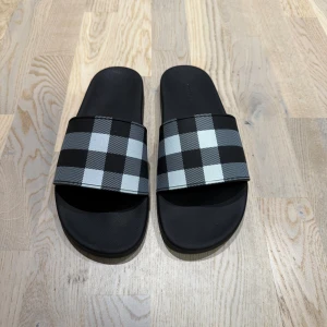 Burberry tofflor - Säljer nu mina burberry tofflor i nyskick. Tofflorna är storlek 46 och 30cm. Endast tofflorna ingår. Rekommenderar stort nu till sommaren. Hör av er vid funderingar 