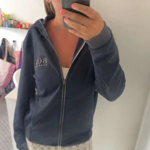 Svart zip-hoodie från Hugo Boss - Använd några gånger innan men kommer inte till användning längre därför säljer jag den. Har några små defekter på armen men inget som man tänker på (se sista bilderna). Står inte vilken storlek men borde passa S/M. Kontakta mig gärna via funderingar eller intresse!😁