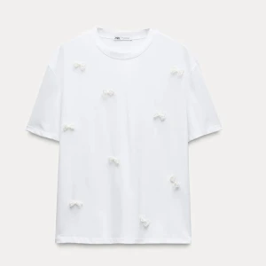Vit t-shirt med detalj - Vit söt t-shirt med ”pärlade rosetter” i storlek S🤍