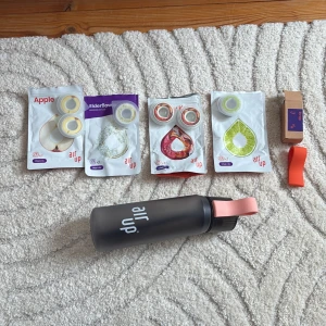 Air Up svart vattenflaska (bara flaska) - Säljer en svart Air Up vattenflaska med matt finish och rosa silikonhandtag. Medföljer flera smakpods i olika smaker som äpple, fläder, körsbär/cola och lime. Perfekt för dig som vill göra vattnet roligare och fräschare med doftsmak. Kommer dubbeldiskas innan jag skickar och det kommer vara ett lite dyrare pris efter som att flaskan kostade en del och att poddarna är till.