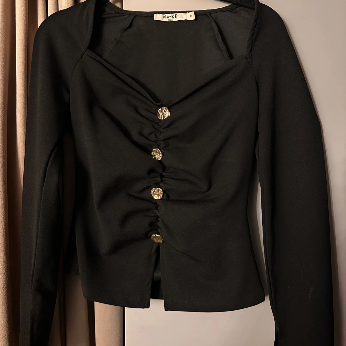 Svart blus med guldknappar från NA-KD