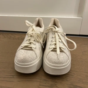 Anna field skor - Unika vita sneakers med hög platåsula och snygg spetsdetalj över hela skon. Skorna har snörning och rund tå, vilket ger en cool och trendig look. Perfekta för dig som vill sticka ut med en feminin touch på dina sneakers. Säljer för ja använt bara en gång o ingen mer. 