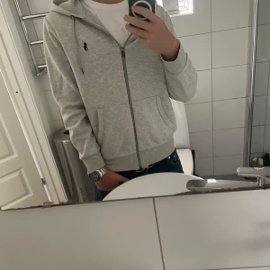 Ralph Lauren zip hoodie - Säljer denna riktigt snygga zip hoodien från Ralph Lauren. Säljer den då den tyvärr inte kommer till användning längre. Storlek S som passar 175cm perfekt. Cond 8/10, inga defekter. Säljer den för 699kr, priset kan diskuteras. Nypris: 2199kr. 