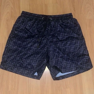 Svarta shorts med logomönster - Säljer svarta shorts med super bra skick. Helt nya och är oanvänd. Priset går att diskuteras!