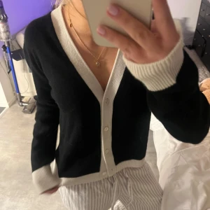 Kashmir kofta Cloeys - 100% Kashmir. Helt ny!Ny pris 2900kr .Säljer en snygg svart kofta från Cloeys med vita detaljer. Koftan har långa ärmar och knappar framtill. Perfekt för en stilren look.