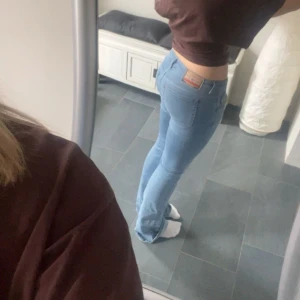 Ljusblå bootcut jeans från Diesel - Säljer ett par ljusblå jeans från Diesel med bootcut passform (de är vidare än på bilden, men lite försmå i benen på mig) . Jeansen har låg midja och är tillverkade i mjukt denimtyg som sitter skönt. Bra i längden för 167 ish🩵