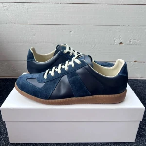 Maison Margiela Skor - Otroligt fina Mörkblåa Maison Margiela Skor i otroligt bra skick! Storleken 44 men passar även 43. Tveka inte att höra av dig vid funderingar! (Äkhetsbevis finns inkl Box)