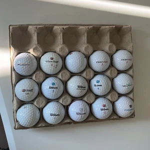 Golf bollar - Bilderna visar en kartong fyllda med golfbollar av olika märken och modeller, bland annat Wilson Staff, Velocity, Deep Red och Duo Soft. Perfekt för dig som vill fylla på golfbagen inför säsongen! Passar både nybörjare och erfarna golfare som vill ha variation på banan.