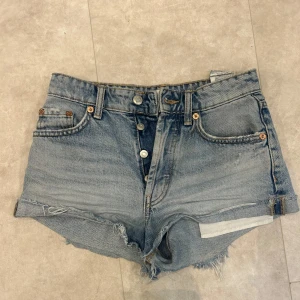 Högmidjade jeansshorts - Snygga högmidjade jeansshorts från Zarai ljusblå denim. Klassisk femficksmodell med knappar framtill och fransig kant nedtill för en avslappnad vibe. Perfekta för varma dagar🥰