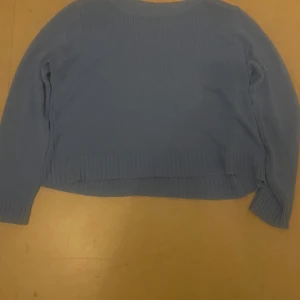 Ljusblå stickad tröja från H&M Divided - Superfin ljusblå stickad tröja från H&M Divided i storlek M. Tröjan har en croppad passform, rund halsringning och långa ärmar. Perfekt att styla med jeans eller kjol för en chill look.