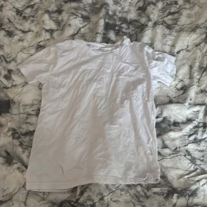 Vit basic t-shirt från 157, S - En klassisk vit t-shirt från 157 i storlek S. Gjord i 100% bomull med rund hals och korta ärmar. Perfekt till jeans eller shorts för en clean och enkel look.