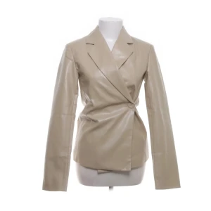 Beige skinnkavaj 🤍 - Snygg beige kavaj från Reclaimed Vintage. Jackan har omlottknäppning med en knapp i sidan. Mycket bra skick. 