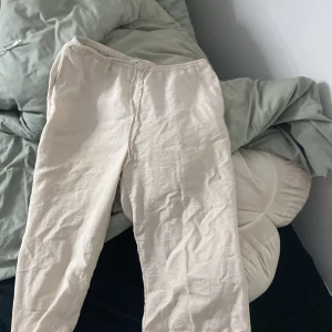 Beiga linnebyxor med snörning - Säljer ett par beiga linnebyxor från H&M med elastisk midja och snörning. Byxorna är raka i modellen och har en avslappnad passform, perfekta för chill dagar. Lätta och luftiga i materialet linne, vilket gör dem sköna att bära under varmare dagar.