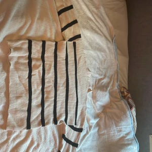 Randig ribbstickad tröja från Vila - Säljer en ribbstickad tröja från Vila i storlek L. Tröjan är vit med svarta vertikala ränder, har lång ärm och en klassisk rund hals. Materialet är mjukt och stretchigt, perfekt för lager-på-lager. Snygg till både jeans och kjol. Har en lite högre krage❤️