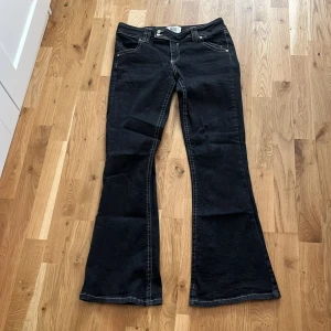 Svarta bootcut jeans från BDG - Snygga svarta bootcut jeans från BDG Urban Outfitters med kontrastsömmar och klassisk femficksdesign. Jeansen har låg midja och är tillverkade i jeansmaterial. 