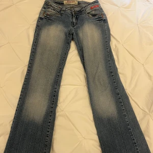 Lågmidjade jeans  - Lågmidjade jeans med coola fickor, småskavanker längst ner på jeansen. MIDJEMÅTT: 35 cm, INNERBENSLÄNGD: 82 cm, MIDJEHÖJD: 16 cm