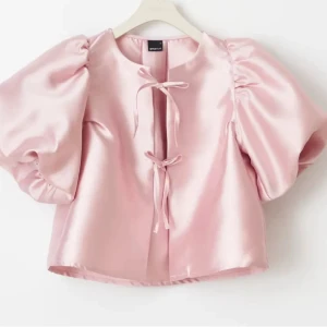 Blus med rosett  - Super fin ”metallic” rosa blus med puffärm. Endast testad🩷. Sista bilden är jag med en likadan svart!! Köpt för 499kr🩷