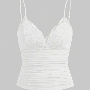 Vit spetslinne med smala axelband - Supersöt vit linnetopp med tunna axelband och spetsdetaljer över bysten. Toppen har v-ringning och en liten rosett framtill. Sitter tight och är perfekt för lager-på-lager eller som den är. Materialet känns mjukt och stretchigt.