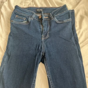 Mörkblå jeans från Happy Holly - Snygga mörkblå jeans från Happy Holly med klassisk femficksdesign och kontrastsömmar. Jeansen har normal passform och är tillverkade i stretchigt material med 98% bomull och 2% elastan för extra komfort. Perfekta till vardagslooken.