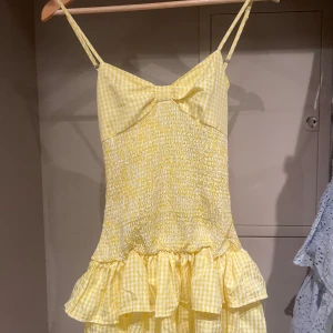 Gul rutig kortklänning med rosett - Supersöt gul och vit rutig kortklänning med en rosett på ryggen💛köpt på plick för 800kr💗 kontakta gärna om du har några frågor eller prisförslag❣️