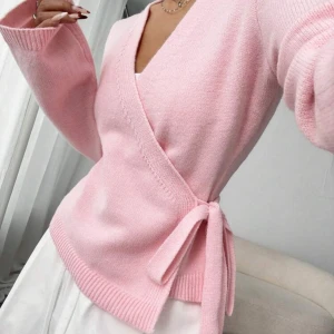 Rosa omlottkofta med knytband - Supersöt rosa omlottkofta med knyt i sidan och v-ringad hals. Koftan är stickad och har långa ärmar med breda muddar. Perfekt för dig som gillar en feminin och trendig look. Använd 1 gång. Köpt för 239kr säljer för 120kr. Vid intresse så kan fler bilder skickas.