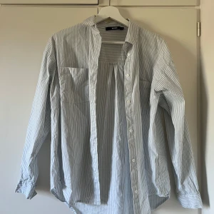 Randig skjorta - Vit och blå randig skjorta från Bikbok i storlek S. Utmärkt skick! Köp gärna bundle och få då extra rabatt!