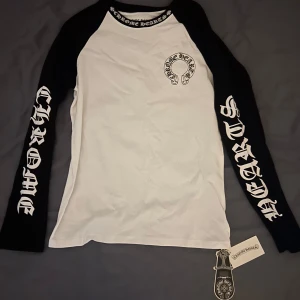 Chrome Hearts långärmad tröja svart/vit - Snygg långärmad tröja från Chrome Hearts i svart och vitt. Tröjan har stora tryck på ärmarna och ryggen med märkets logga och text. Kontakta vid fler frågor svarar snabbt!
