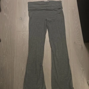 Grå bootcut mjukisbyxor från Gina Tricot - Mysiga grå yoga pants från Gina Tricot med bootcut-ben . Perfekta för chill dagar eller när du vill ha något riktigt bekvämt. Mjukt material som känns skönt mot huden.