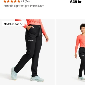 Svarta träningsbyxor Revolution race NY - Lätta svarta träningsbyxor från RVRC med elastisk midja och snörning. Byxorna har en rak passform, diskret logga på låret och är perfekta för aktiva dagar. Materialet känns smidigt och andas bra. Helt nya med lapp kvar