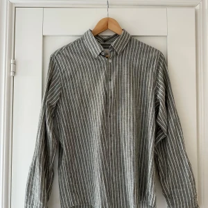 Randig skjorta från Skagen Clothing  - LÅNGÄRMAD LINNESKJORTA ARMYRANDIG Långärmad linneskjorta i armyrandig från Skagen Clothing. Använde några gånger, men är fortfarande i bra skick. Nypris 1015kr. Pris kan diskuteras vid en snabb affär 