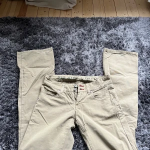 Beige byxor från Big Star - Snygga beige byxor från Big Star med klassisk design. Byxorna har en rak passform och är utrustade med knappar och dragkedja. Perfekta för en avslappnad stil.