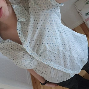Vit blommig blus - Säljer en sommrig vit blus med små blommiga mönster i blått och grönt💙💚 Lite genomskinlig men är superfin med linne under❣️ Inte min stil så säljer därför, bara att höra av sig vid intresse☺️